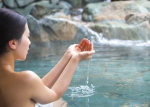 お湯を救い上げる女性